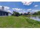 Lakeside home showcasing the serene water view, lush green lawn, and inviting outdoor space for relaxation at 5974 San Michelle Dr, Sarasota, FL 34243