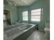 Bright bathroom featuring a large soaking tub, mosaic tile floor, and dual pane window at 5974 San Michelle Dr, Sarasota, FL 34243