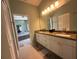Bright primary bathroom with double sinks, granite countertops, and a view of the bathtub at 5974 San Michelle Dr, Sarasota, FL 34243