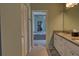 Hallway leading to primary bathroom with double sinks, granite countertops, and a view of the bathtub at 5974 San Michelle Dr, Sarasota, FL 34243