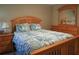 Cozy bedroom with a wooden bed frame, leaf-patterned bedding, and wooden dresser at 5974 San Michelle Dr, Sarasota, FL 34243