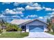 Charming one-story home with light blue garage door, mature landscaping and tile roof at 5974 San Michelle Dr, Sarasota, FL 34243