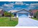 Charming one-story home with light blue garage door, mature landscaping and tile roof at 5974 San Michelle Dr, Sarasota, FL 34243