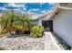 Landscaped front yard featuring palm trees and decorative stone at 5974 San Michelle Dr, Sarasota, FL 34243