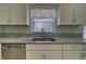 Bright kitchen featuring stainless steel sink, granite counters and white cabinets at 5974 San Michelle Dr, Sarasota, FL 34243
