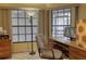 Bright home office features a wooden desk, neutral chair, and large windows at 5974 San Michelle Dr, Sarasota, FL 34243