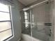 Updated bathroom showcasing a tiled shower with sliding glass doors and modern fixtures at 5974 San Michelle Dr, Sarasota, FL 34243