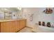 Well-lit bathroom with a double vanity, a soaking tub, and stylish decorative accents at 6512 Midnight Pass Rd # 206, Sarasota, FL 34242