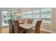 Elegant dining room featuring a large table, wicker chairs, and sliding glass doors to a balcony at 6512 Midnight Pass Rd # 206, Sarasota, FL 34242