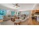 Bright living room with comfortable seating, hardwood floors, and a partial kitchen view at 6512 Midnight Pass Rd # 206, Sarasota, FL 34242
