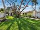 Inviting backyard showcasing a lush green lawn, mature trees, and access to the house at 691 Linley St, Longboat Key, FL 34228