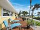 Spacious balcony featuring two blue lounge chairs and views of the palm trees and ocean at 691 Linley St, Longboat Key, FL 34228