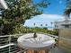 Outdoor balcony with water views, a white metal railing, and a table with chairs at 691 Linley St, Longboat Key, FL 34228