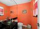 Stylish powder room featuring a unique glass bowl sink and an orange accent wall at 691 Linley St, Longboat Key, FL 34228