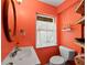 Bathroom featuring bright paint, a white sink, matching toilet and wood-framed round mirror at 691 Linley St, Longboat Key, FL 34228