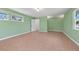 A bright, empty bedroom with tile floors, light-green walls, and multiple windows at 691 Linley St, Longboat Key, FL 34228