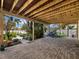 Spacious brick carport featuring a garden view, bikes, and stairs leading to the upper level at 691 Linley St, Longboat Key, FL 34228