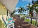 Outdoor deck showcases chairs, table, and coastal view with palm trees, a lovely spot for relaxing or entertaining at 691 Linley St, Longboat Key, FL 34228