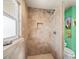 Corner shower featuring stone-look tile walls, a built-in niche, a shower head and a window for natural light in the bathroom at 691 Linley St, Longboat Key, FL 34228