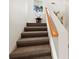 Carpeted staircase with wooden handrail leads to upper floor with decoratively painted walls at 691 Linley St, Longboat Key, FL 34228