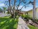Scenic backyard with a brick pathway, vibrant greenery, and a charming garden at 691 Linley St, Longboat Key, FL 34228
