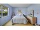 Serene bedroom with a large window, soft blue walls, and carpet, offering a relaxing retreat at 7860 Palm Aire Ln # 104, Sarasota, FL 34243