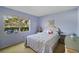 Serene bedroom with a large window, soft blue walls, and carpet, offering a relaxing retreat at 7860 Palm Aire Ln # 104, Sarasota, FL 34243