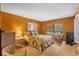 Comfortable bedroom featuring a queen bed, warm orange walls, and bright natural light for relaxing ambiance at 7860 Palm Aire Ln # 104, Sarasota, FL 34243