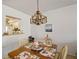Bright dining area featuring a charming chandelier and a view into the kitchen at 7860 Palm Aire Ln # 104, Sarasota, FL 34243