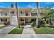 Inviting two-story condo with balconies, a front door entry, lush greenery, and a parking garage at 7860 Palm Aire Ln # 104, Sarasota, FL 34243