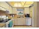 Efficient kitchen features white appliances, tile flooring, and bright lighting for a practical cooking space at 7860 Palm Aire Ln # 104, Sarasota, FL 34243