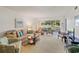 Bright living room with large sliding doors overlooking a manicured lawn and patio seating at 7860 Palm Aire Ln # 104, Sarasota, FL 34243