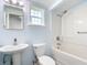 Cozy bathroom featuring a pedestal sink, toilet, tub with shower, and a mirrored medicine cabinet at 8430 Truman St, Englewood, FL 34224