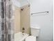 Bright bathroom with a shower-tub combo with tile surround, toilet and towel bar at 8430 Truman St, Englewood, FL 34224