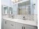 Stylish bathroom featuring a double sink vanity with tile backsplash and mirrored medicine cabinets at 8430 Truman St, Englewood, FL 34224