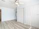 Open bedroom with wood-look floors, white trim, and a closet for storage at 8430 Truman St, Englewood, FL 34224