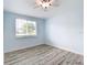 Bright bedroom with a ceiling fan, gray wood-look floors, and a window letting in natural light at 8430 Truman St, Englewood, FL 34224