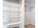 Walk-in closet with white walls, white shelving, and wood-look floors at 8430 Truman St, Englewood, FL 34224