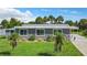 Well-kept single-story home with a lush green lawn and palm tree landscaping at 8430 Truman St, Englewood, FL 34224
