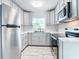 Kitchen featuring stainless steel appliances, white cabinets, and mosaic tile backsplash at 8430 Truman St, Englewood, FL 34224