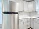 Kitchen with stainless steel refrigerator, drawers and gray cabinets, and mosaic backsplash at 8430 Truman St, Englewood, FL 34224