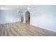 Bright living room with wood-look floors, ceiling fan, and arched doorways at 8430 Truman St, Englewood, FL 34224