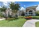 Beautiful exterior elevation showcasing stone accents, manicured landscaping and a well-maintained lawn at 9828 58Th E St, Parrish, FL 34219