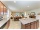 Open concept kitchen with granite counters, brown cabinets, that flows into the dining and living areas at 9828 58Th E St, Parrish, FL 34219