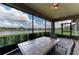Enclosed lanai with tile flooring and outdoor table, offering a scenic view at 9828 58Th E St, Parrish, FL 34219