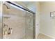 Walk-in shower with glass door, rainfall showerhead, tiled walls, and a built-in soap dish at 9828 58Th E St, Parrish, FL 34219