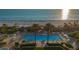 Stunning aerial view of a beachfront pool with clear blue ocean in the background at 1241 Gulf Of Mexico Dr # 1005, Longboat Key, FL 34228
