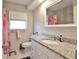 Updated bathroom featuring a vanity with a granite countertop, and tiled walls and flooring at 1409 2Nd E Ave, Bradenton, FL 34208