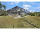 The back of the home has a screened-in patio and pool, with an elevated flower bed, and green lawn at 14205 Nighthawk Ter, Lakewood Ranch, FL 34202