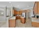 Bright kitchen with stainless steel appliances, central island, light countertops and matching wood cabinets at 14205 Nighthawk Ter, Lakewood Ranch, FL 34202